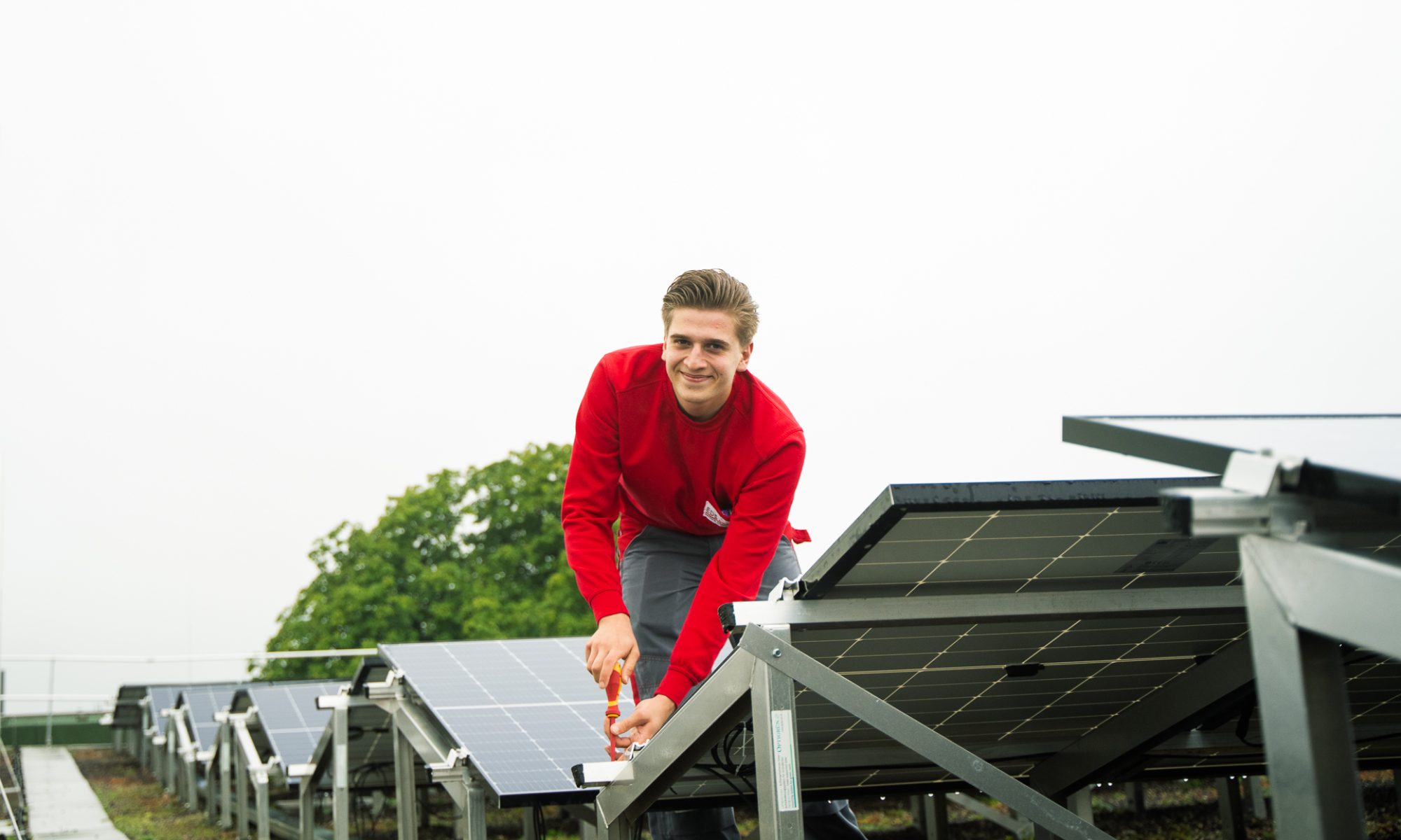 Ein Handwerker montiert eine Solaranlage auf einem Dach und arbeitet dabei sicher und präzise.